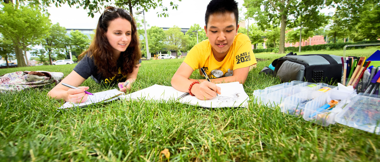 two students studying on the pentacrest