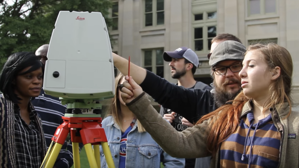 A group of students and teacher operating a machine.